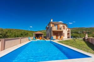 a villa with a swimming pool in front of a house at Family house with swimming pool in Novi Vinodolski
