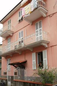 a man is looking out of a pink building at Domo Nina in La Spezia