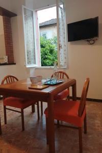 a dining room table with chairs and a window at Domo Nina in La Spezia