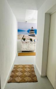 a hallway with a table with a picture of the ocean at SOTAVENTO Salmarina in Sanlúcar de Barrameda +17 photos
