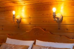 1 dormitorio con 2 luces en una pared de madera en Gästehaus Kayetan, en Klais