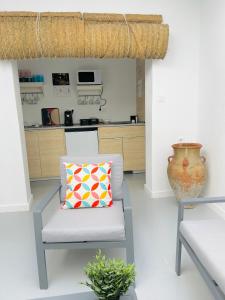 a living room with a chair and a vase at SOTAVENTO Salmarina in Sanlúcar de Barrameda
