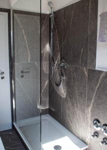 a shower with a glass door in a bathroom at Gästehaus Kayetan in Klais