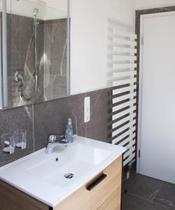 bagno con lavandino bianco e specchio di Gästehaus Kayetan a Klais