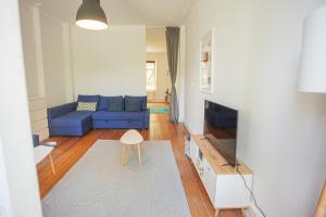 Sehr zentral / Hell / Altbau في هامبورغ: غرفة معيشة مع أريكة زرقاء وتلفزيون