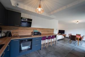 una cocina con armarios azules y taburetes morados en Le Doux Paradis - Maison 4 Chambres en Doussard