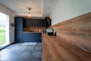 cocina con armarios azules y pared de madera en Le Doux Paradis - Maison 4 Chambres en Doussard