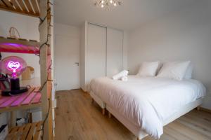 1 dormitorio con 1 cama blanca grande y escritorio en Le Doux Paradis - Maison 4 Chambres en Doussard