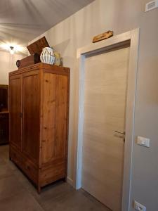 a closet with a wooden door and a wooden cabinet at Gli Ulivi Rooms in Lucca