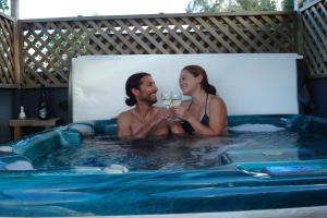 a man and a woman sitting in a hot tub at Olde Mill House B&B & Bike2Wine cycle hire in Renwick