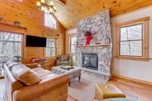 un soggiorno con divano e camino in pietra di Jeffersonville Home with Deck Near Hiking and Climbing a Jeffersonville