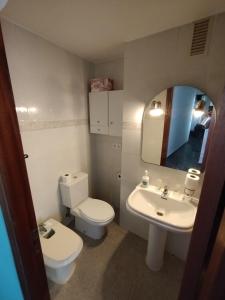 y baño con aseo, lavabo y espejo. en ushuaia, en Castellón de la Plana