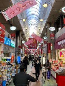 大阪市にあるNew Open 天神橋筋六丁目駅徒歩1分 バーカウンター付き一軒家 天満居酒屋街徒歩3分 梅田 難波10分の商店街を歩く人々