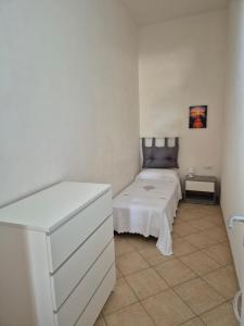 1 dormitorio con 1 cama blanca y vestidor blanco en LaCasaDiVito en Marsala