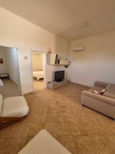 uma sala de estar com um sofá e uma televisão em LaCasaDiVito em Marsala