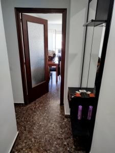 a hallway with a door and a table and a mirror at ushuaia in Castellón de la Plana