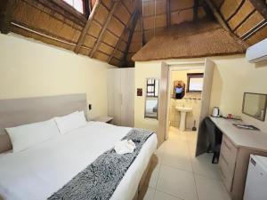 a bedroom with a bed and a bathroom with a sink at THE GALAXY FOREST LODGE in Manguzi +120 photos