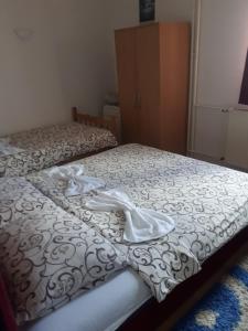 um quarto com 2 camas e lençóis brancos em Apartman Break 1 em Bijeljina