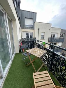 a balcony with a table and chairs on a balcony at Chez André - Appartement 4 personnes Parking Vieux-Lille in Saint-André