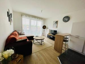 a living room with a couch and a refrigerator at Chez André - Appartement 4 personnes Parking Vieux-Lille in Saint-André