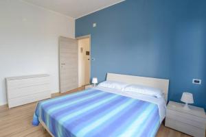 瓦多利古雷的住宿－Casa Lilly Ristrutturata con AC，一间卧室设有一张蓝色墙壁的大床