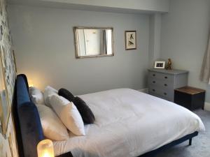 1 dormitorio con 1 cama con sábanas y almohadas blancas en Grove Place - 2 Bedroom apartment Leamington Spa en Leamington Spa