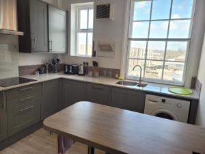 cocina con mesa de madera y fregadero en Grove Place - 2 Bedroom apartment Leamington Spa en Leamington Spa