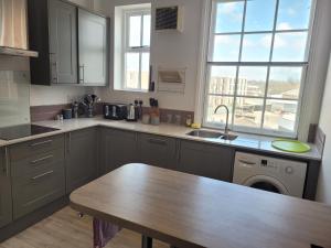 a kitchen with a wooden table and a sink at Grove Place - 2 Bedroom apartment Leamington Spa in Leamington Spa