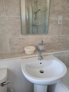 y baño con lavabo blanco y espejo. en Grove Place - 2 Bedroom apartment Leamington Spa en Leamington Spa