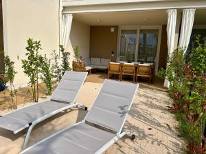 2 weiße Sessel auf einer Terrasse in der Unterkunft Resminik Home in Lido di Jesolo