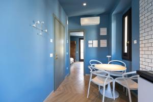 a dining room with blue walls and a table and chairs at Portosole Apartments in Porto SantʼElpidio