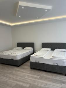 two beds in a room with white walls at Davud Apartments in Sarajevo