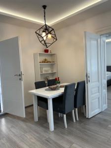 comedor con mesa blanca y sillas en Davud Apartments en Sarajevo