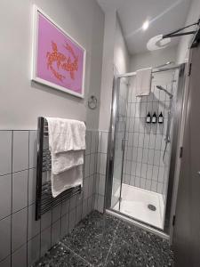 uma casa de banho com um chuveiro e uma porta de vidro em Number One - Townhouse em Kinsale