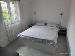 een witte slaapkamer met een bed en een raam bij Apartment Murva in Premantura