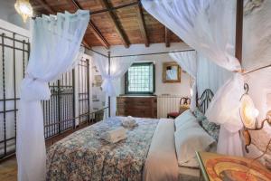 a bedroom with a bed with white drapes at Antico Mulino Baderem in Sorisole