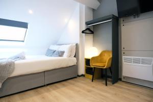 a small bedroom with a bed and a yellow chair at Breckfield House by Serviced Living Liverpool in Liverpool