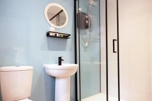a bathroom with a toilet and a shower with a mirror at Breckfield House by Serviced Living Liverpool in Liverpool
