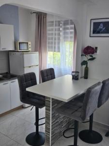 a kitchen with a white table and chairs at Apartments Aurora in Jezera