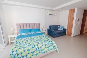 a bedroom with a bed and a blue chair at Apartamento de lujo en Rodadero Santa Marta in Santa Marta