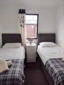 two beds sitting next to each other in a bedroom at Ardbeg 4 - Farm Stay with Sea Views across to Northern Ireland in Stranraer