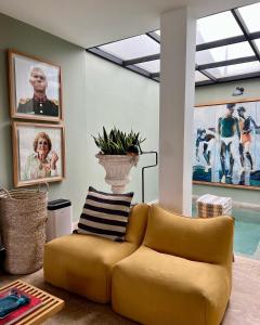 a yellow couch in a living room with pictures at Villa Augustine in Tangier