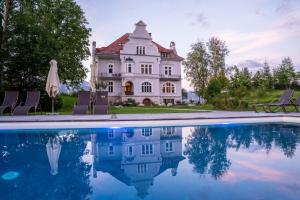 une grande maison avec une piscine en face de celle-ci dans l'établissement Villa Bergzauber, à Rossleithen