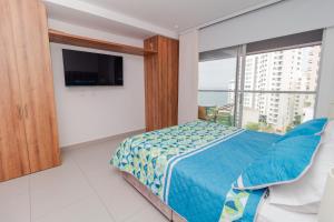 een slaapkamer met een bed en een groot raam bij Hermoso Apartamento tipo Loft en Rodadero Santa Marta in Santa Marta