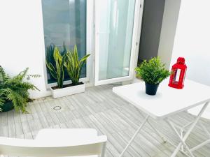 a room with a white table and potted plants at SOTAVENTO La Solera in Sanlúcar de Barrameda