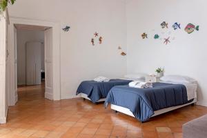 - 2 lits dans une chambre avec des papillons sur le mur dans l'établissement Casa Giosuè - Your home on the Amalfi Coast, à Conca dei Marini
