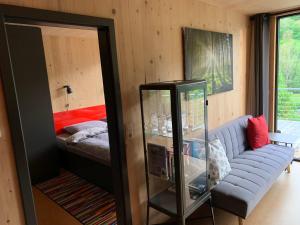 a living room with a couch and a bed at Tiny Häuser im Kupfertal in Forchtenberg