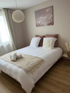 ein Schlafzimmer mit einem großen Bett mit weißer Bettwäsche und Kissen in der Unterkunft chez max et laurie in Souvans