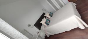 1 dormitorio con 1 cama blanca y 2 almohadas en Finca Rural La Casa Verde Shalom Tenerife, en La Laguna