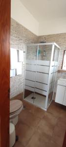 a bathroom with a toilet and a glass shower at Finca Rural La Casa Verde Shalom Tenerife in Las Lagunas